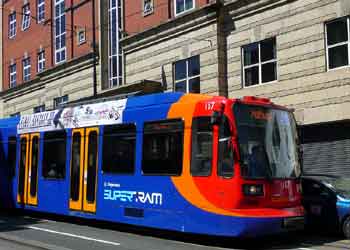 Light rail / tram / streetcar overhead wire supported from building walls.