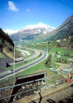 The view out the window showing a snow capped mountain peak in the distance - and a twin carriageway motorway.