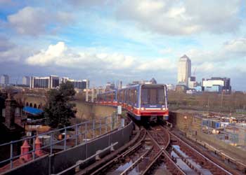 London Docklands Light Railway on a viaduct and Canary Wharf tower in the distance behind.