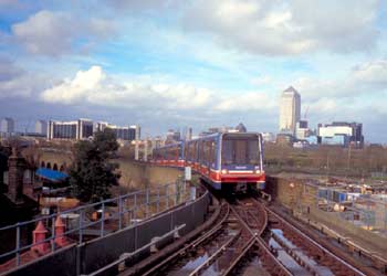 London Docklands Light Railway on a viaduct and Canary Wharf tower in the distance behind.