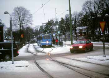 A snowy tram and roadway scene in Stockholm.