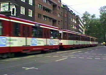 Triple unit street tram in a suburban street where it happily co-exists with road users.