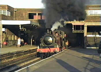 Plumes of black smoke from a steam engines as it passes through Wembley Park Station in north London.